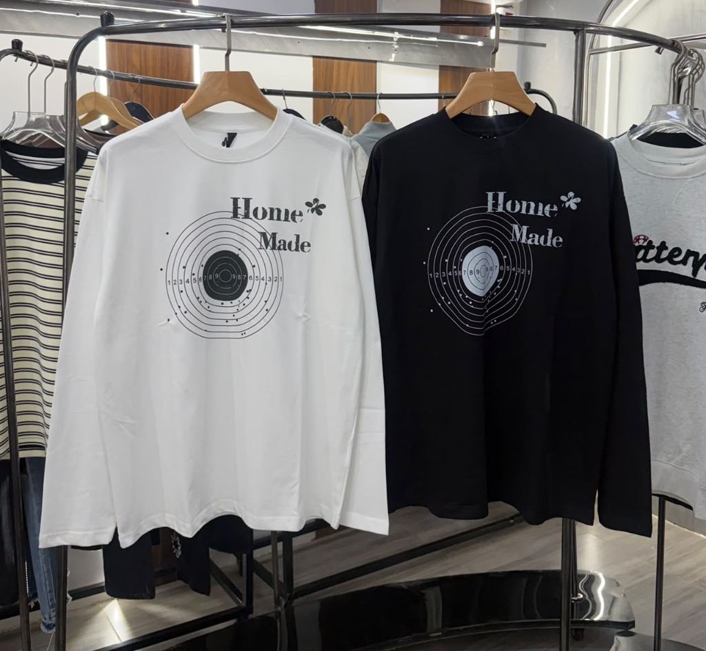 long-sleeve striped crewneck sweaters and t-shirts on a clothing rack